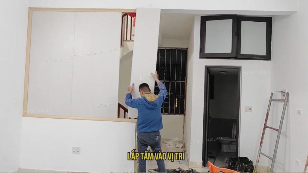 Luồn tấm nhựa vách ngăn phòng vào chân đế đã cố định sẵn